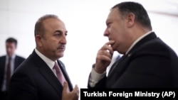 Turkish Foreign Minister Mevlut Cavusoglu (left) talks with U.S. Secretary of State Mike Pompeo at the Esenboga Airport in Ankara on October 17.