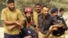 Pakistani policemen remove an injured colleague from a training center after gunmen attacked in Lahore.