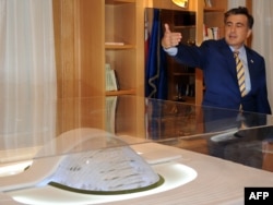 Saakashvili poses with a model of the glassy parliament in May 2011.