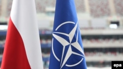 Флаг Польши и флаг НАТО перед Национальным стадионом в Варшаве, где проходит саммит. 8 июля