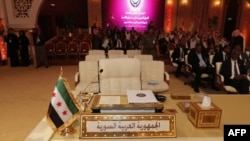 A pre-Ba'ath regime Syrian flag, currently used by the opposition, is seen in front of the seat of the Syrian delegation at the opening the Arab League summit in Doha on March 26.