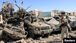 Members of the Afghan security force keep watch at the site of a suicide bomb attack in Ghazni Province, September 4, 2014