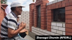 Аманбай Арзыгулов читает молитву у могилы жены и сына, умерших во время пандемии коронавируса. Актобе, 7 августа 2020 года.
