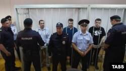 Russia -- Aleksander Margolin, Ilya Gushchin and Aleksei Gaskarov (L-R), charged with rioting on Bolotnaya Square on May 6, 2012, are seen in a cage during the announcement of the verdict in a Moscw court, Aug. 18, 2014 
