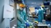 Belgium - Doctors - Medical workers put on their protective gears before working on March 27, 2020, at the unit for coronavirus COVID-19 infected patients at the Erasme Hospital in Brussels. (Photo by Kenzo TRIBOUILLARD / AFP)