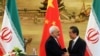 Iranian Foreign Minister Mohammad Javad Zarif (left) shakes hands with his Chinese counterpart, Wang Yi, at a bilateral meeting in Beijing. Iran has in recent months increasingly reached out to China in the face of growing U.S. pressure to isolate Tehran. (file photo)