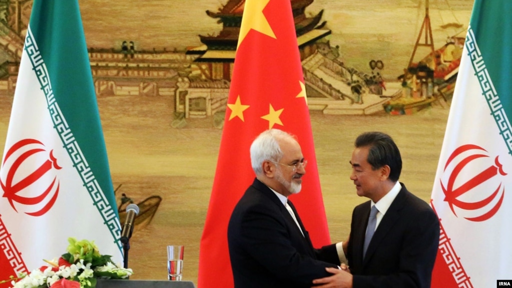 Iranian Foreign Minister Mohammad Javad Zarif (left) shakes hands with his Chinese counterpart, Wang Yi, at a bilateral meeting in Beijing. Iran has in recent months increasingly reached out to China in the face of growing U.S. pressure to isolate Tehran. (file photo)