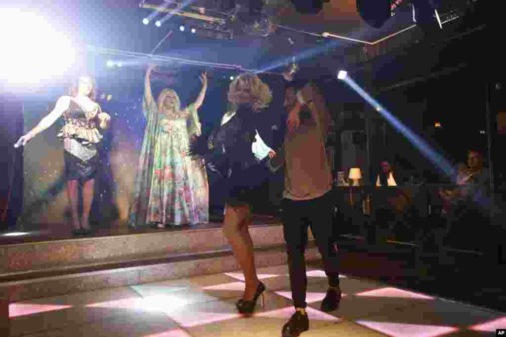 A visitor to "Mayak" dances the "lezginka," a Caucasian national dance, with a performer at the cabaret show. 