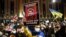 Demonstrators hold up signs and wave flags during a rally in support of Ukraine in Tbilisi on February 28.