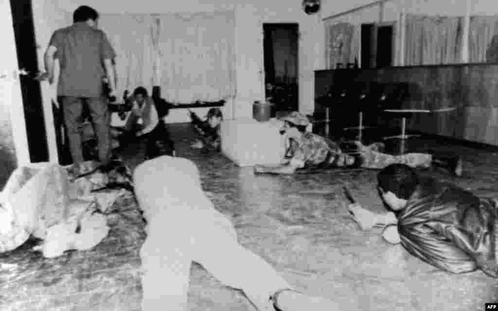 Venezuelan soldiers loyal to President Carlos Andres Perez and journalists lie in one of the entrance rooms of the presidential palace of Mirafiores in Caracas after rebels led by Chavez attacked the palace on February 2, 1992.