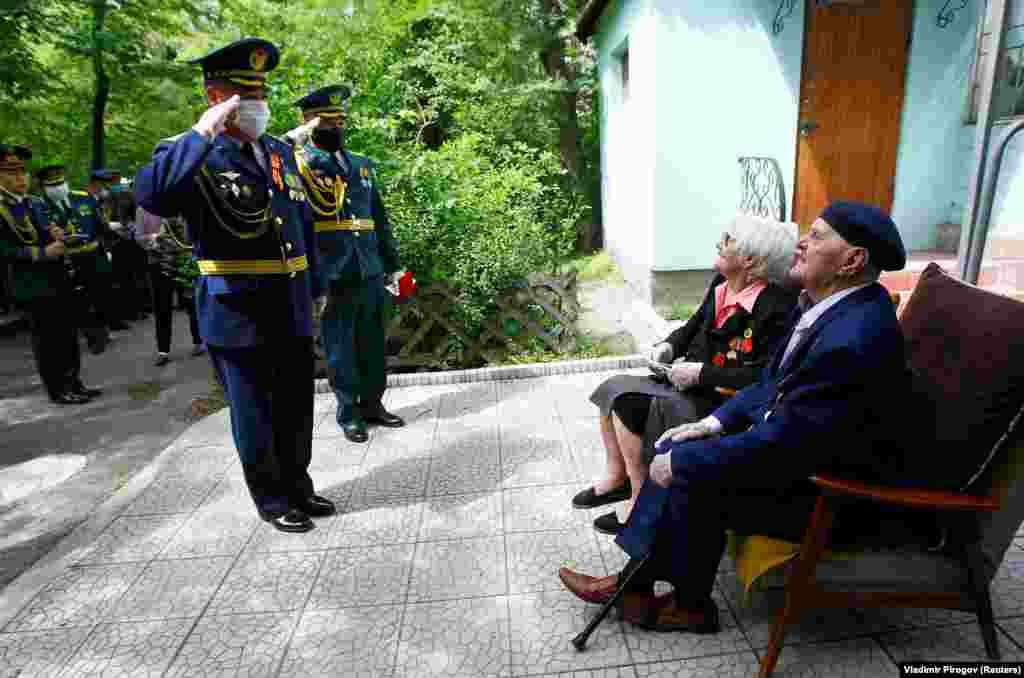 Masked Kyrgyz servicemen salute World War II veterans outside an apartment block in Bishkek during the 75-year celebrations of victory over Nazi Germany on May 9.