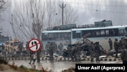 Indian paramilitary soldiers stand by the wreckage of a bus after an explosion in Pampore in Indian-controlled Kashmir on February 14.