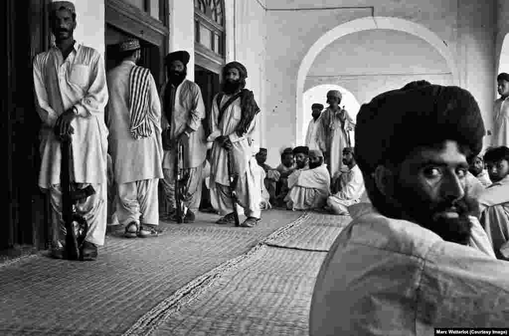 Outside the front door of the late tribal leader Nawab Akbar Khan Bugti&#39;s home, several Bugti tribesmen stand guard, while others wait for an audience with their chieftain.