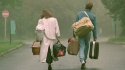 HUNGARY -- With bag and bag this pair arrives on Monday, 04. Sept. 1989 in front of the refugee camp Csilleberc near Budapest, where more than a thousand GDR citizens are waiting for their departure to West Germany.