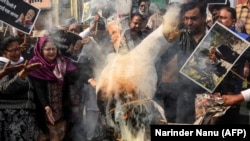 Congress Party workers shout slogans as they burn an effigy of India's Prime Minister Narendra Modi (C) during a demonstration in the northern city of Amritsar to protest against the violence in the capital New Delhi.