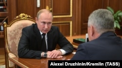 Președintele rus Vladimir Putin vorbind cu ministrul apărării Sergei Şoigu. 2 iulie 2019