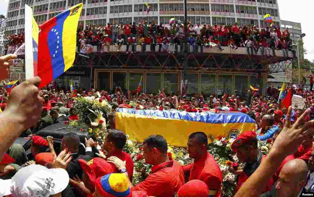 Venecuela - Povorka sa kovečegom sa Chaveozovim tijelom, prekirivenim venecualanskom zastavom, kretala se prepunim ulicama Caracasa od bolnice u kojoj je Chavez umro do Vojne akademije gdje će njegovo tijelo biti izloženo do sahrane, 6. mart 2013. Foto: REUTERS / Carlos Garcia Rawlins