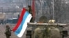 Russian soldiers unfold their flag in Grozny in 2000 