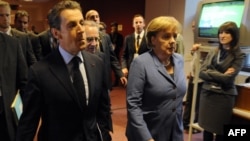 German Chancellor Angela Merkel (second from right) and French President Nicolas Sarkozy (second from left) on their way to brief the press on the outcome of eurozone debt talks. 