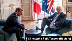 French President Emmanuel Macron and British Prime Minister Boris Johnson speak during a meeting at the Elysee Palace in Paris, August 22, 2019