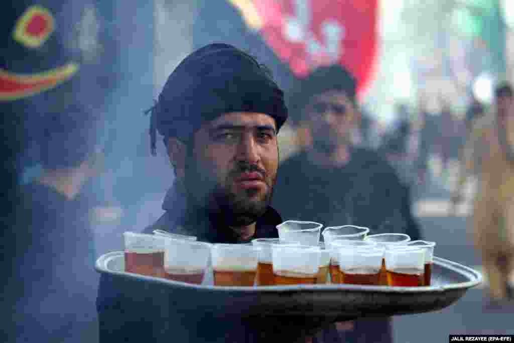 An Afghan Shi'ite Muslim serves drinks during the Islamic sacred month of Muharram in Herat, Afghanistan. (epa-EFE/Jalil Rezayee)
