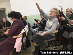 Members of the congregation raise their hands during the service hoping they will be selected to read out loud.