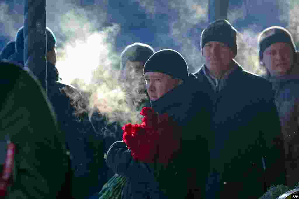 People attend a farewell ceremony for a family who died when an apartment building collapsed in Magnitogorsk, Russia. (AFP)