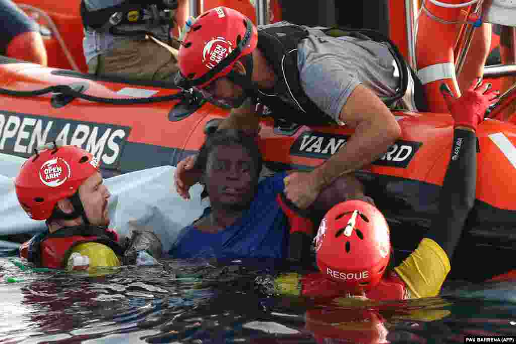 Members of the Spanish NGO Proactiva Open Arms rescue a migrant woman whose boat sank in the Mediterranean off the Libyan coast. (AFP/Pau Barrena)