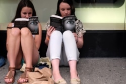 دو خواننده رمان «پنجاه طیف...» در انتظار برای دریافت امضای نویسنده، در نیویورک، ۲۰۱۵