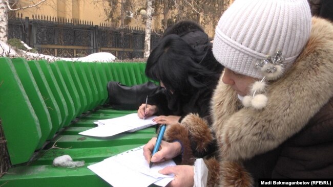 Ulttyq bank aldynda aryz toltyryp jatqan kommerııalyq bank boryshkerleri. Almaty, 19 aqpan 2014 jyl.