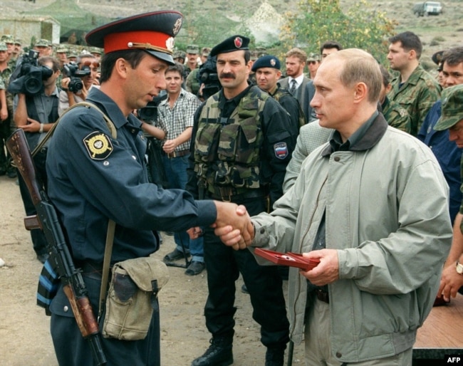 Tada premijer Rusije Vladimir Putin, uručuje nagradu nepoznatom dagestanskom milicajcu u ruskoj bazi u planinama Botlih u Dagestanu 27. avgusta 1999.