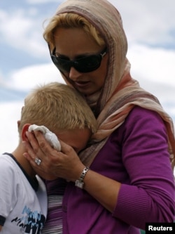 A Bosnian Muslim child is comforted as he cries during a mass funeral for victims killed during the 1992-95 war.