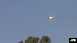 A video grab allegedly shows a Syrian jet fighter on fire after being hit by rebel fire over a village near the eastern city of Deir el-Zour on August 13.