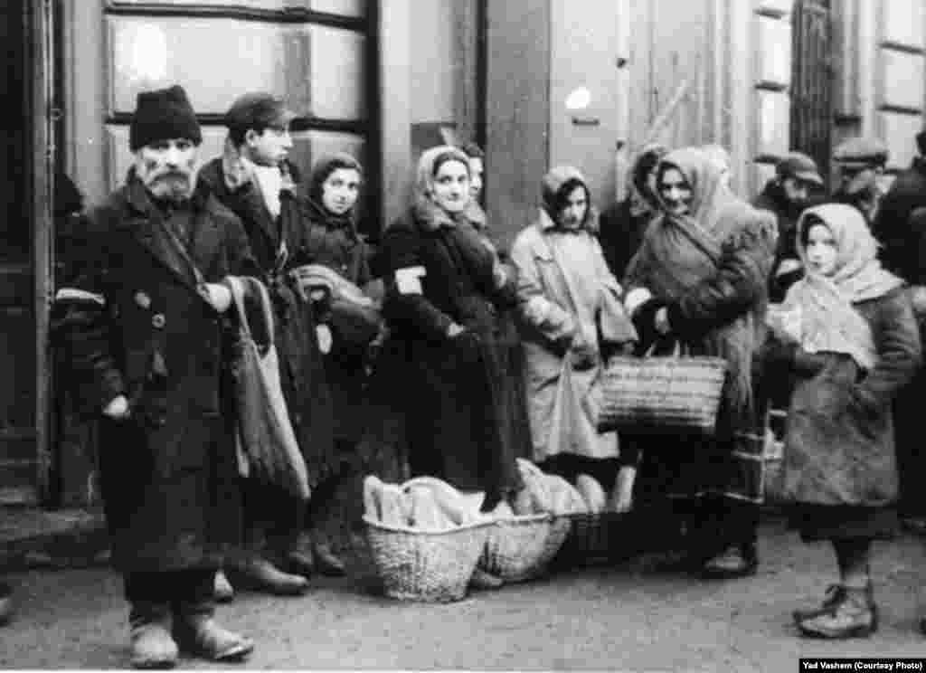 Jews stand by bread baskets on a ghetto street. 