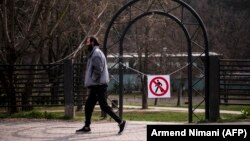 Stanovnik Prištine prolazi pored znaka zabrane ulaska u park u Prištini, 22. mart 2020. godine