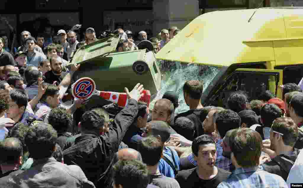 A crowd attacks a minibus carrying gay-rights activists during an International Day Against Homophobia rally in Tbilisi, Georgia. (Reuters)