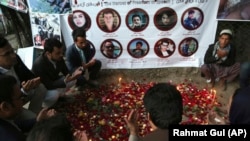 Afghans pray and light candles to pay tribute to Afghan journalists killed in a suicide attack in Kabul in April.