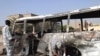 Iraqi police inspect a burnt bus at the site of a bomb attack in Baghdad on November 24.