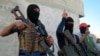 Masked Sunni gunmen pose with their weapons during a patrol outside the city of Fallujah, which remains largely in rebel hands.