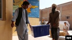 Afghan workers unload election material for the June 14, 2014 presidential runoff vote.