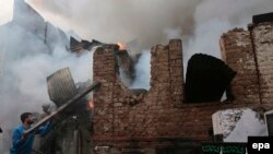 A Kashmiri man tries to demolish the wall during the fire in Srinagar, the summer capital of Indian Kashmir, on November 21.