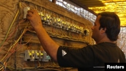 Iraq -- An electrician works on an electric switchboard of a local generator in Baghdad, 22Jun2010