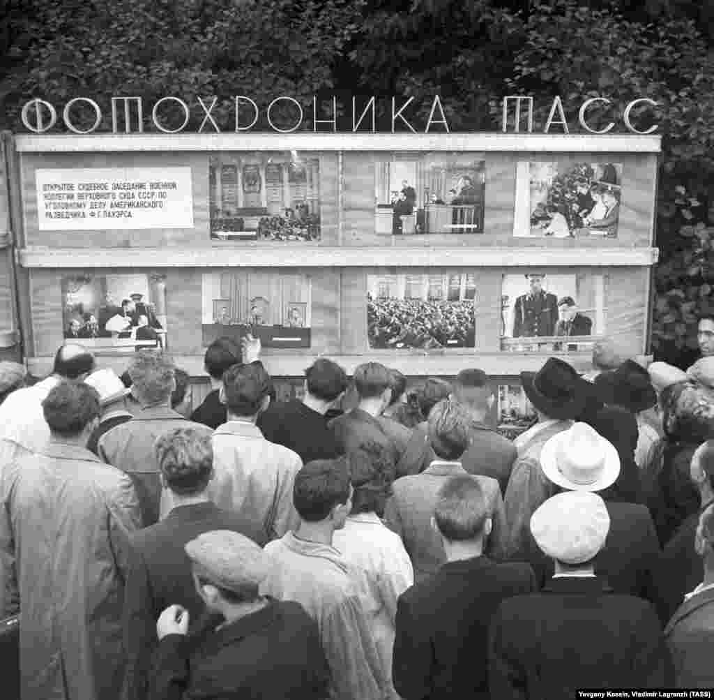 Люди осматривают фотографии процесса над Пауэрсом на информационной доске советского информагентства ТАСС