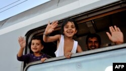 Djeca izbjeglice mašu iz voza u blizini Tovarnika u Hrvatskoj, 17. septembar 2015.
