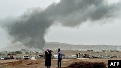 Smoke rises from the the Syrian town of Kobani after a strike from a US-led coalition against Islamic State militants who are besieging the city.