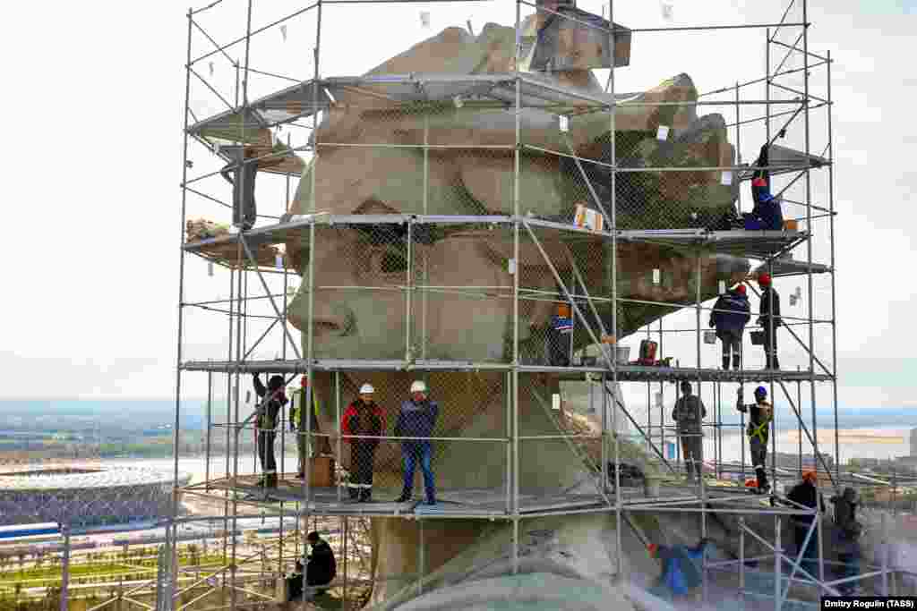 Teams of restorers at work on the monument’s head in September.