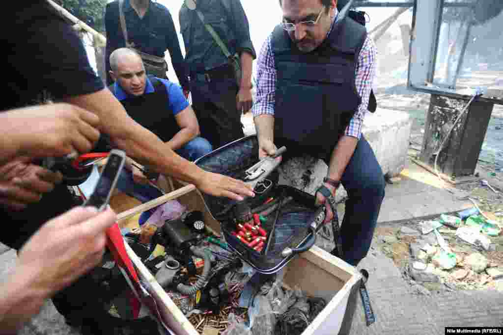 Security forces search a weapons cache which they said was found at the protest camp.