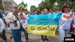Участники марша за территориальную целостность Украины несут ткань в цветах украинского флага с надписью: "Севастополь- это Украина". Одесса, 19 мая 2018 года.