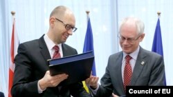 Բելգիա -- Եվրոպական խորհրդի նախագահ Հերման Վան Ռոմպեյը (աջ) և Ուկրաինայի վարչապետ Արսենի Յացենյուկը փոխանակում են ստորագրված փաստաթուղթը, 21 մարտի, 2014