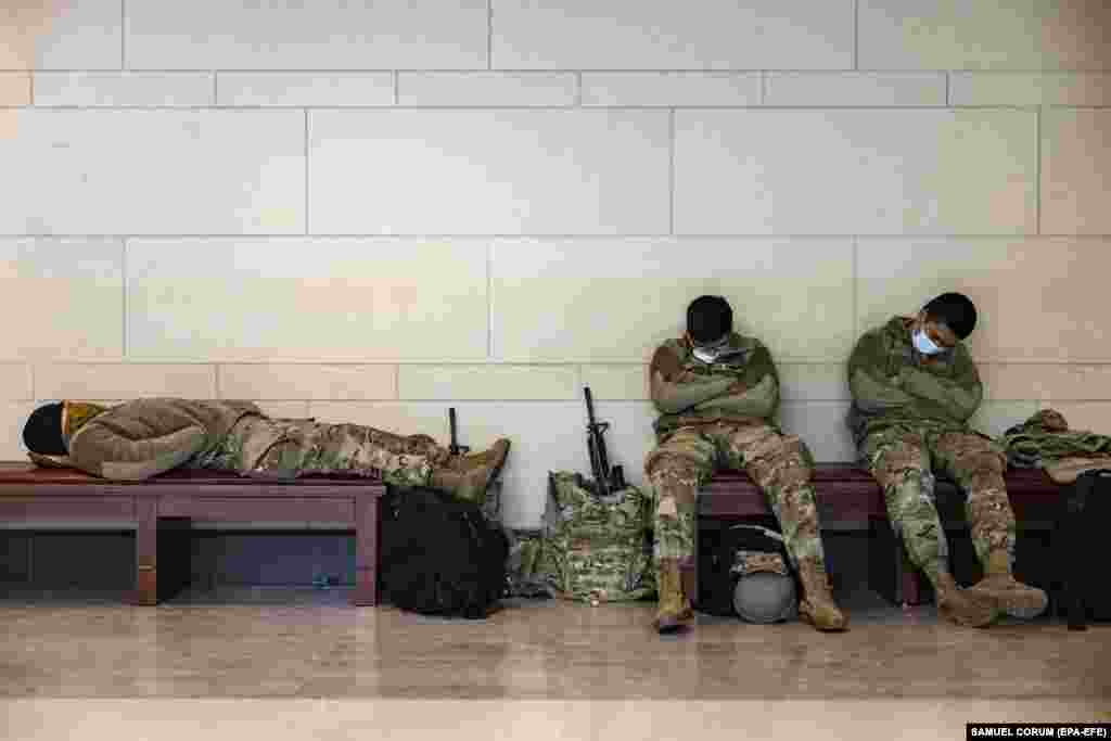 National Guard soldiers rest in the Capitol Visitor Center bellow the U.S. Capitol during a break in their guard shifts in Washington, DC, January 14, 2021.